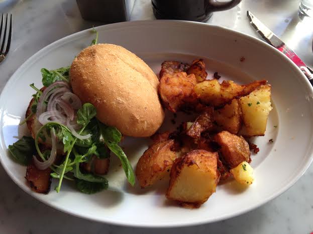 The breakfast Sandwich ($13) with fried potatoes ($6) and Stumptown coffee ($4)